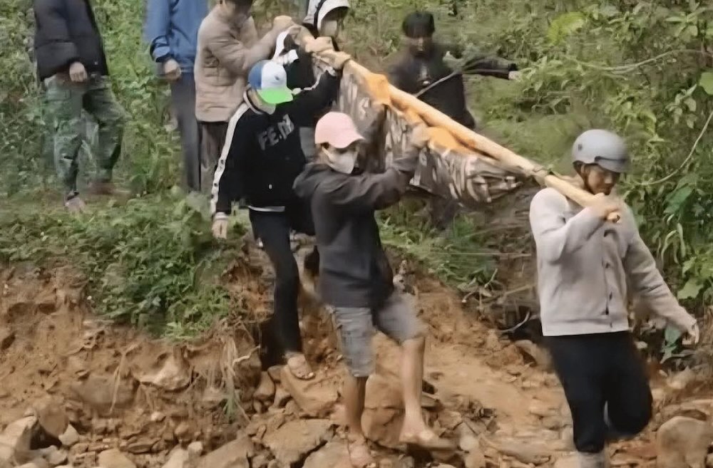 Landslides cut off roads to the village, people cross the forest to carry patients to the emergency room. Photo: Han Nguyen
