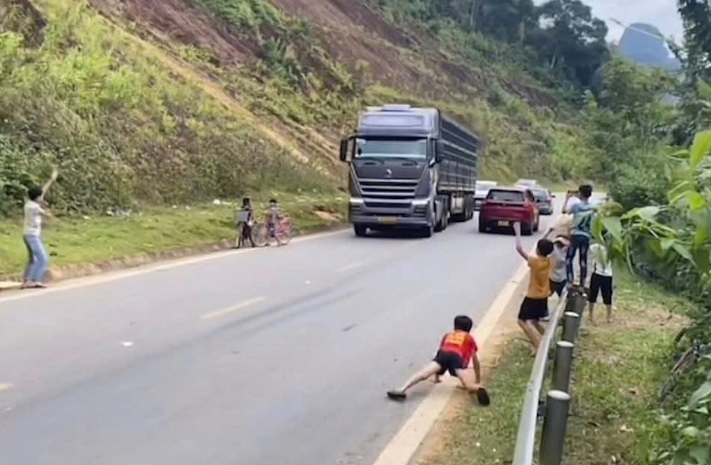 Children standing on the roadside waving car hands is a dangerous act. Photo: Quang Tri Traffic Police
