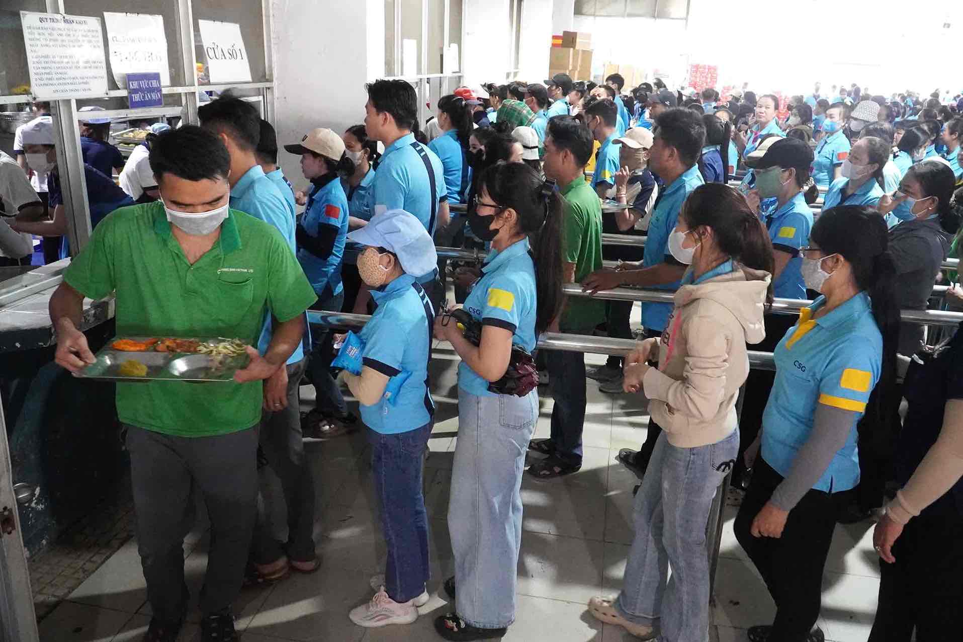 Nguoi lao dong xep hang cho lay phan an. Anh: HAC