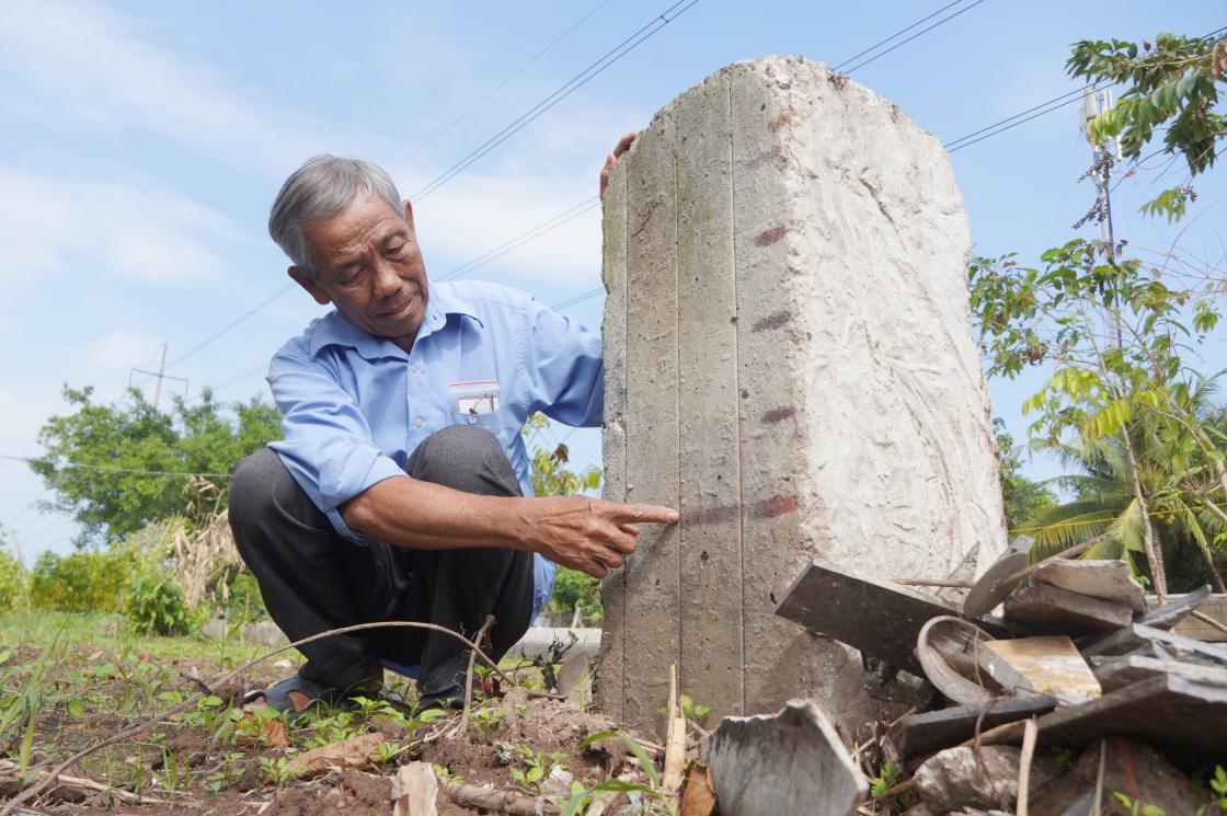 Ông Nguyễn Văn Dành bên cái cọc đã được đóng xuống cách đây nhiều năm. Ảnh: Tạ Quang