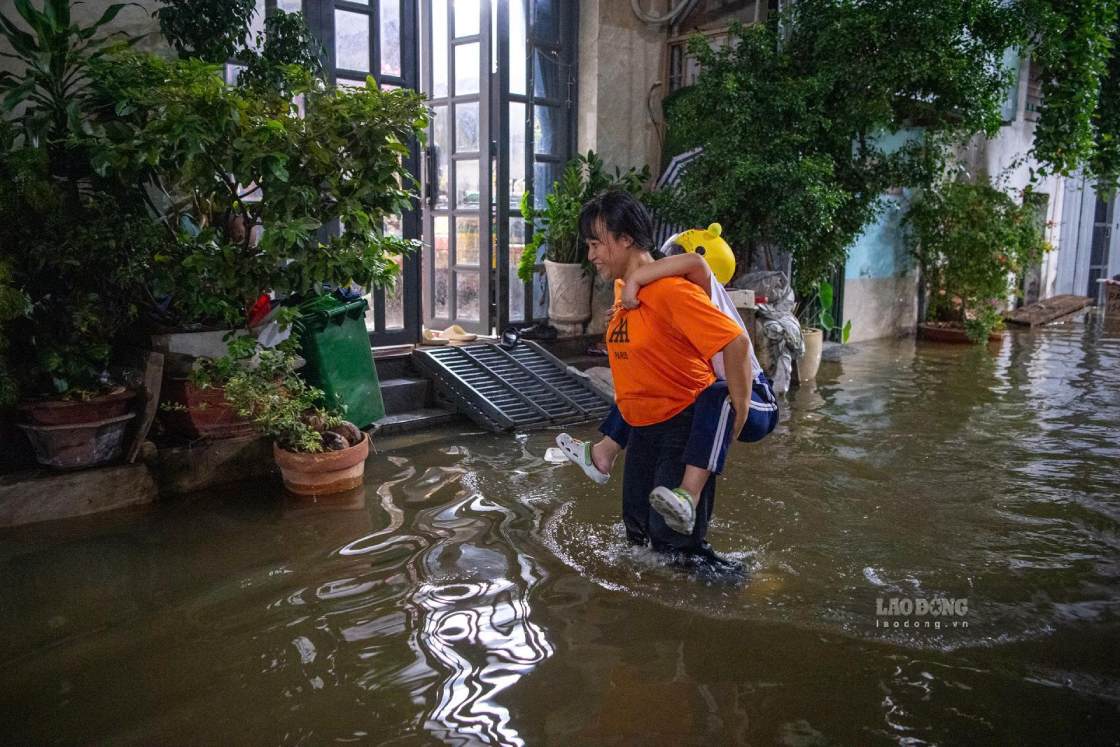 Người dân bất lực nhìn dòng nước tràn vào hẻm, ảnh hưởng đến sinh hoạt. Ảnh: Thái Bảo