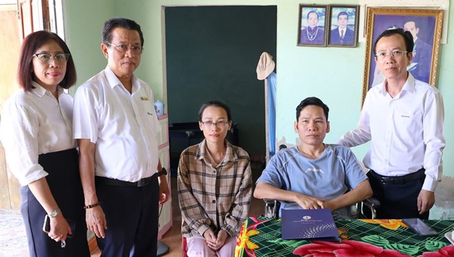 Tổng Giám đốc EVNCPC Ngô Tấn Cư trao kinh phí hỗ trợ của EVNCPC và cá nhân ông cho anh Hồ Xuân Trâm. Ảnh: EVNCPC