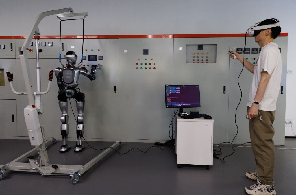 Một nhân viên điều khiển robot hình người để sửa chữa thiết bị điện tại một trung tâm huấn luyện trí tuệ nhân tạo ở Trung Quốc. Ảnh: Xinhua