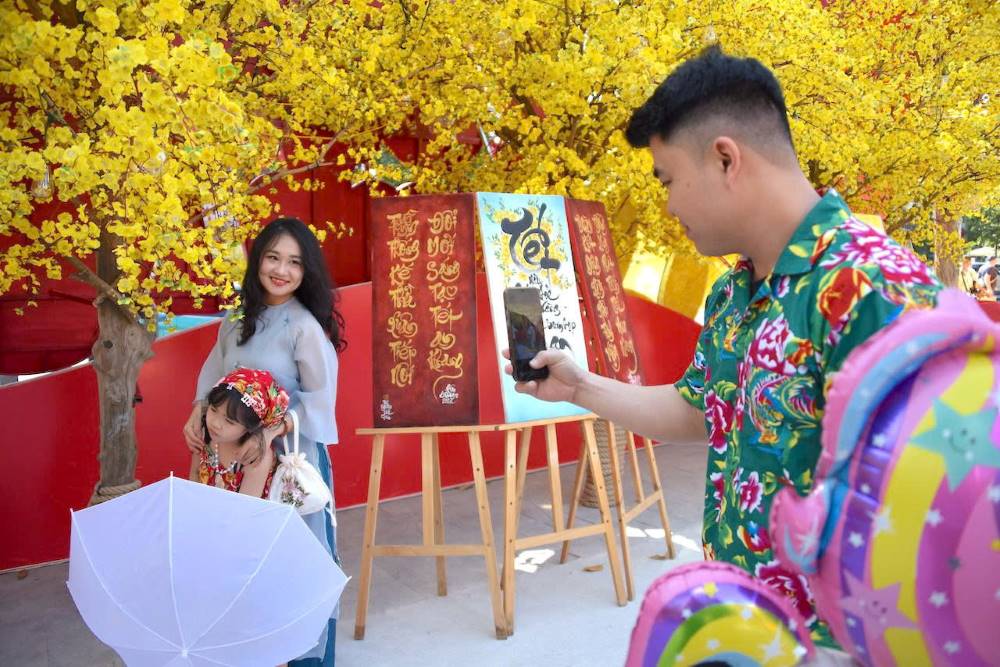   Không gian Phố Ông Đồ và đường mai tại Nhà văn hóa Thanh niên nhộn nhịp người dân đến thưởng lãm không khí Tết cổ truyền giữa lòng phố thị. Ảnh: Thái Bảo