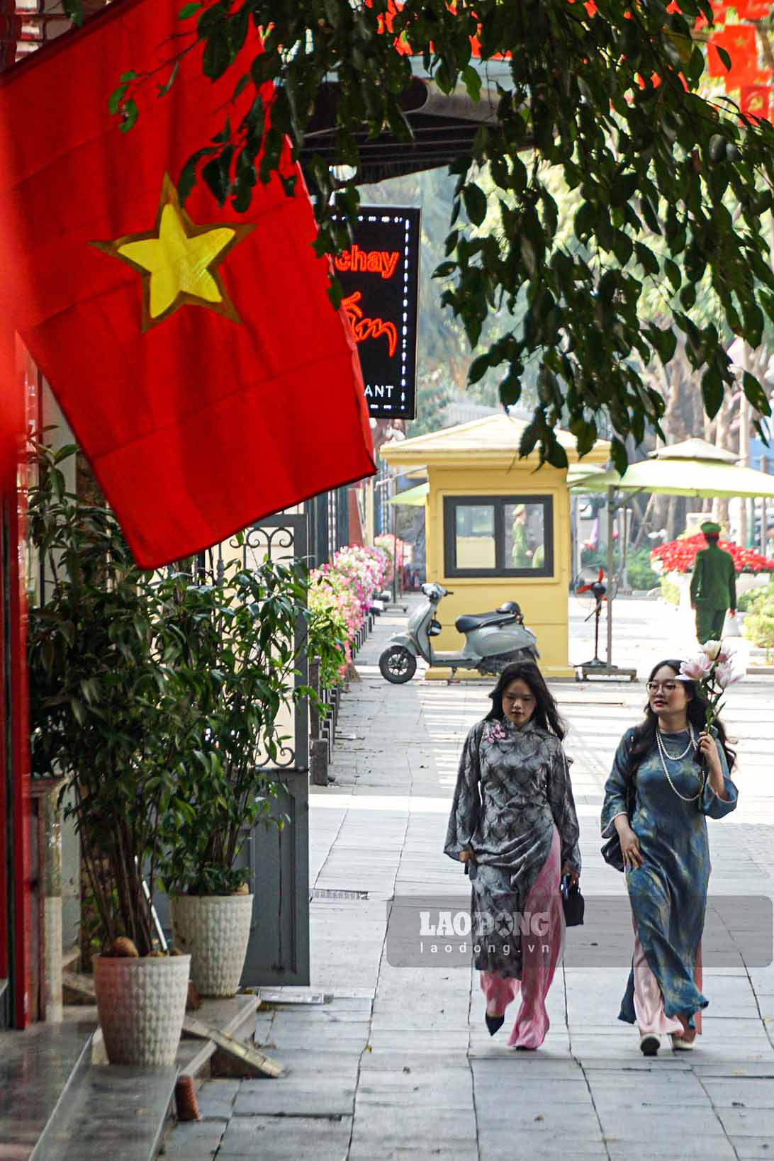 Người dân tản bộ trong không khí kỷ niệm 96 năm Ngày thành lập Đảng lan tỏa trên nhiều tuyến phố của Thủ đô.