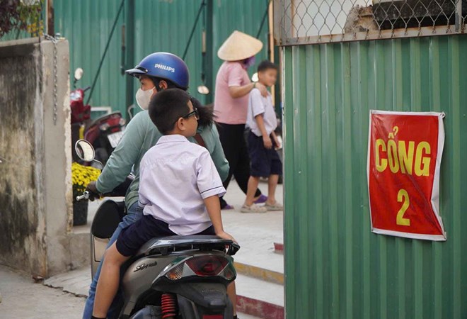 Phụ huynh Trường Tiểu học Nguyễn Văn Hưởng đón con về buổi trưa khi trường dừng bán trú vì nghi vấn đơn vị cung cấp suất ăn sử dụng thịt hết hạn. Ảnh: Chân Phúc