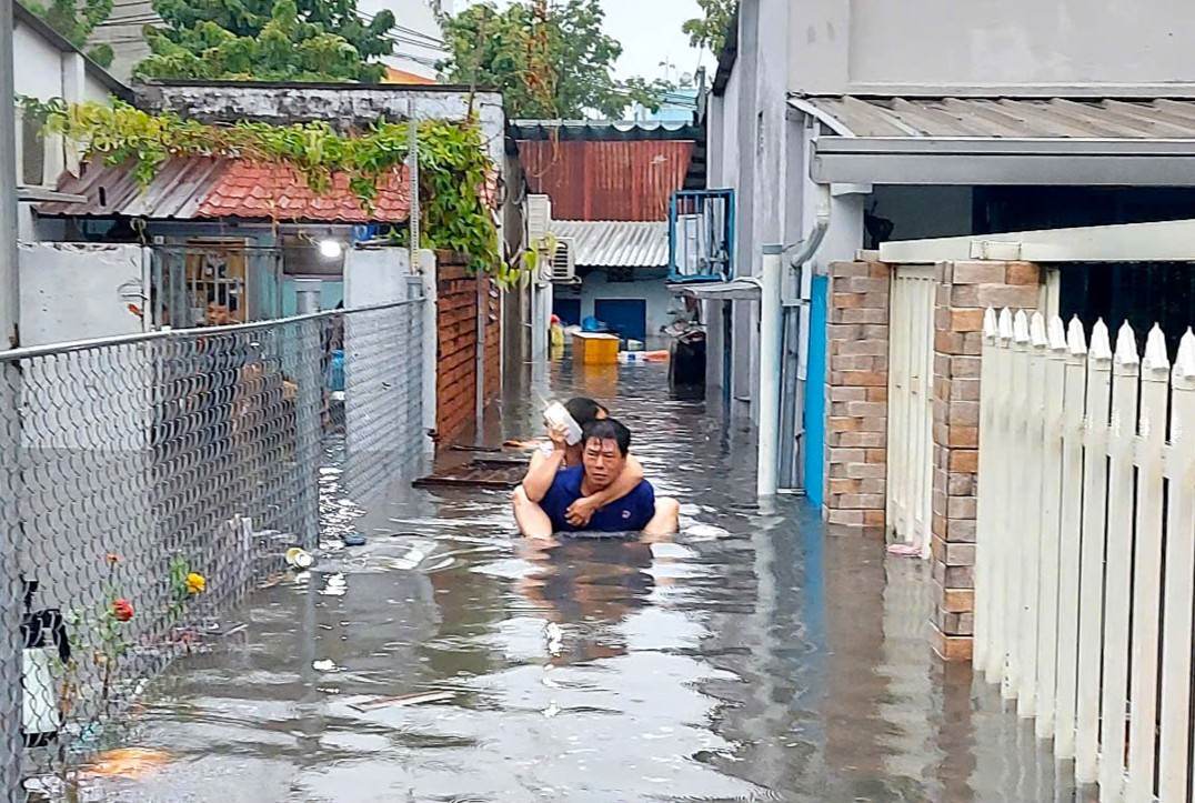 People in Ho Chi Minh City have to carry each other to evacuate due to flooding. Photo: Minh Quan