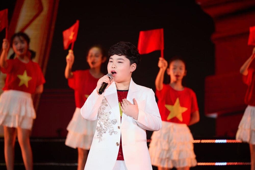 Child singer Duong Duc Hai has a confident performance in the art program "Spring Homeland". Photo: Character provided