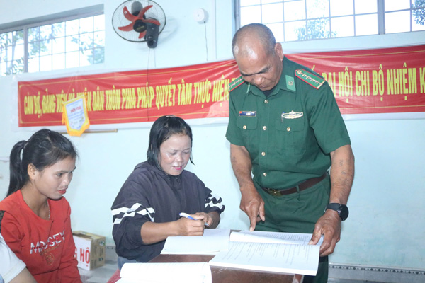 Đại úy A Bừng giúp học viên rà soát lại lỗi chính tả, tự viết tên tuổi chính mình. Ảnh: Thanh Tuấn 