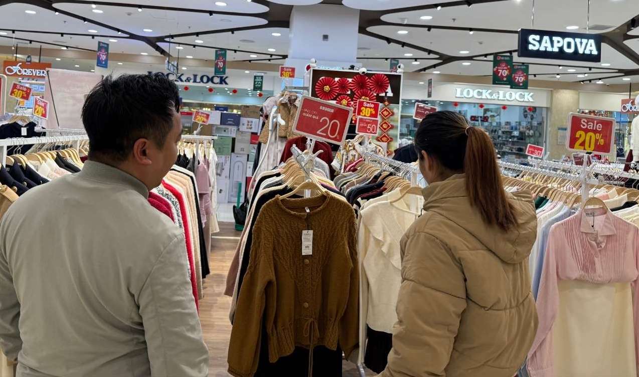 Người dân tranh thủ lựa chọn quần áo giảm giá tại các cửa hàng thời trang trong những ngày cận Tết. Ảnh: Phương Anh