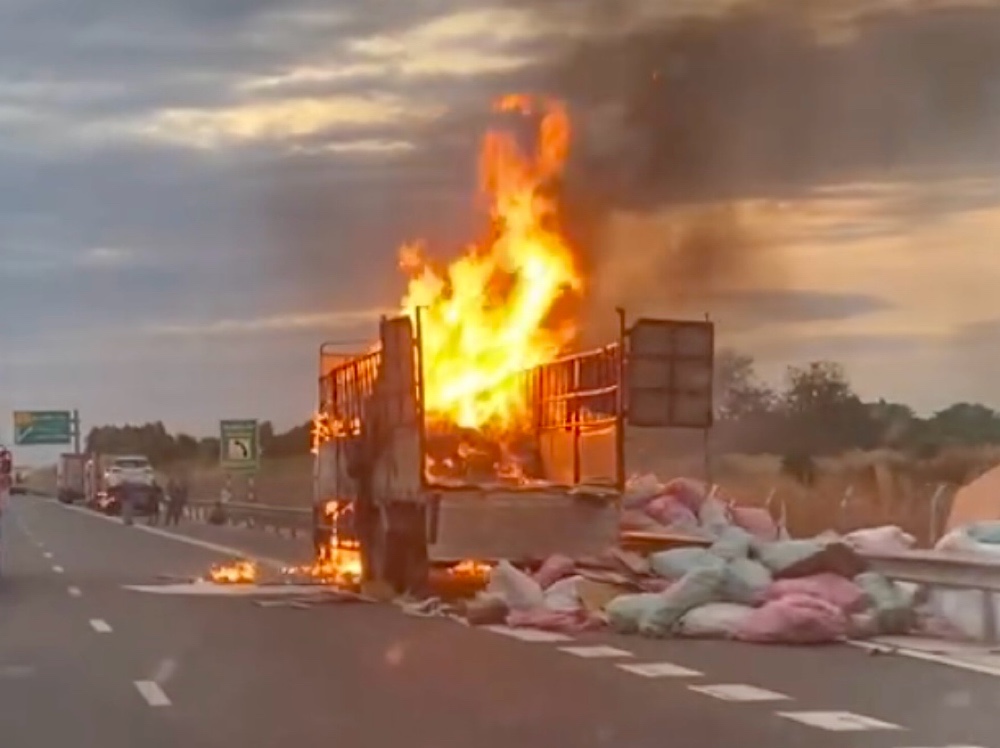 Nhiều bao tải hàng hóa trên thùng xe được kéo xuống đường. Ảnh: Phạm Duy 
