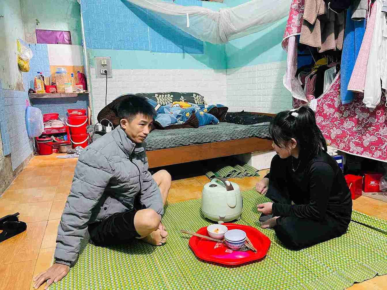 Mr. Lo Van Xuong and his wife sit in a cramped rented room, waiting for the pot of boiled bamboo shoots to cook to prepare dinner. Photo: Mai Huong
