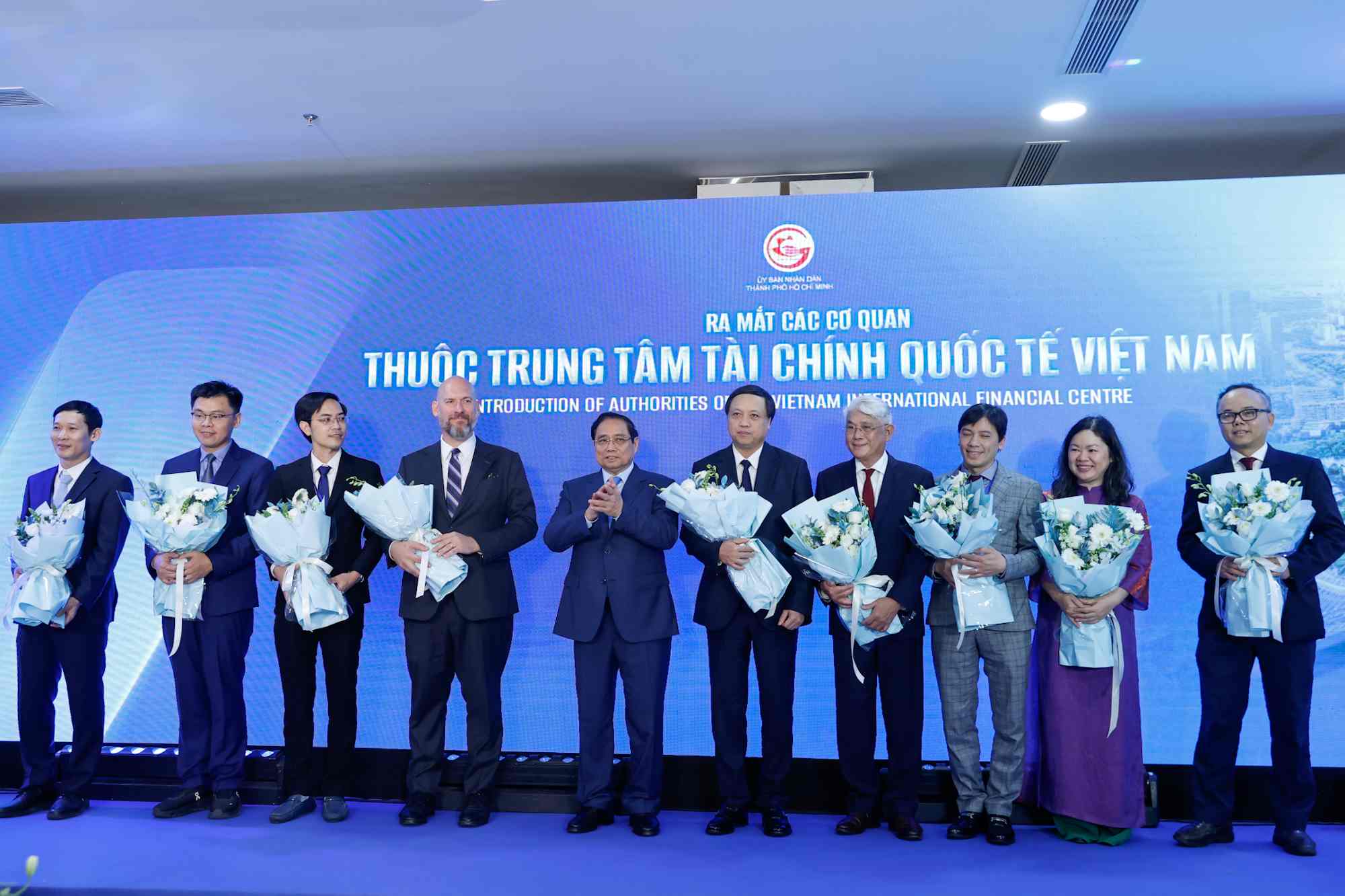 Thủ tướng Chính phủ Phạm Minh Chính tặng hoa cho đại diện các cơ quan thuộc Trung tâm Tài chính quốc tế Việt Nam. Ảnh: VGP/Nhật Bắc