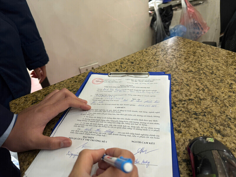 Cơ quan chức năng yêu cầu các hộ kinh doanh ký cam kết văn minh thương mại. Ảnh: Khánh Linh