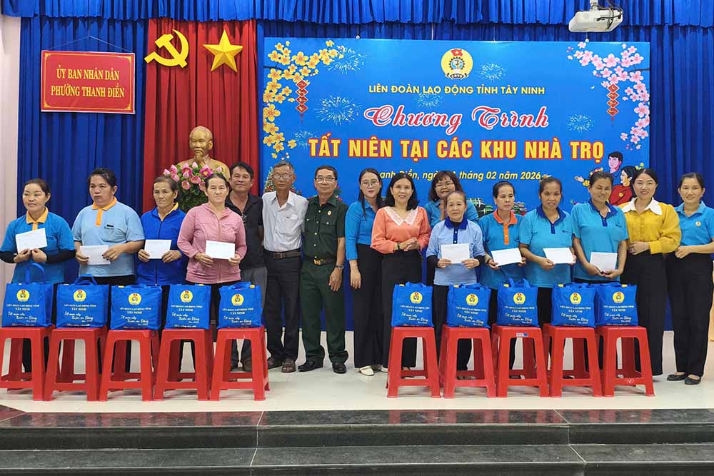 Leaders of the Tay Ninh Provincial Labor Federation take souvenir photos with union members and workers at the Tet gift-giving program in the boarding house area. Photo: Le Tam