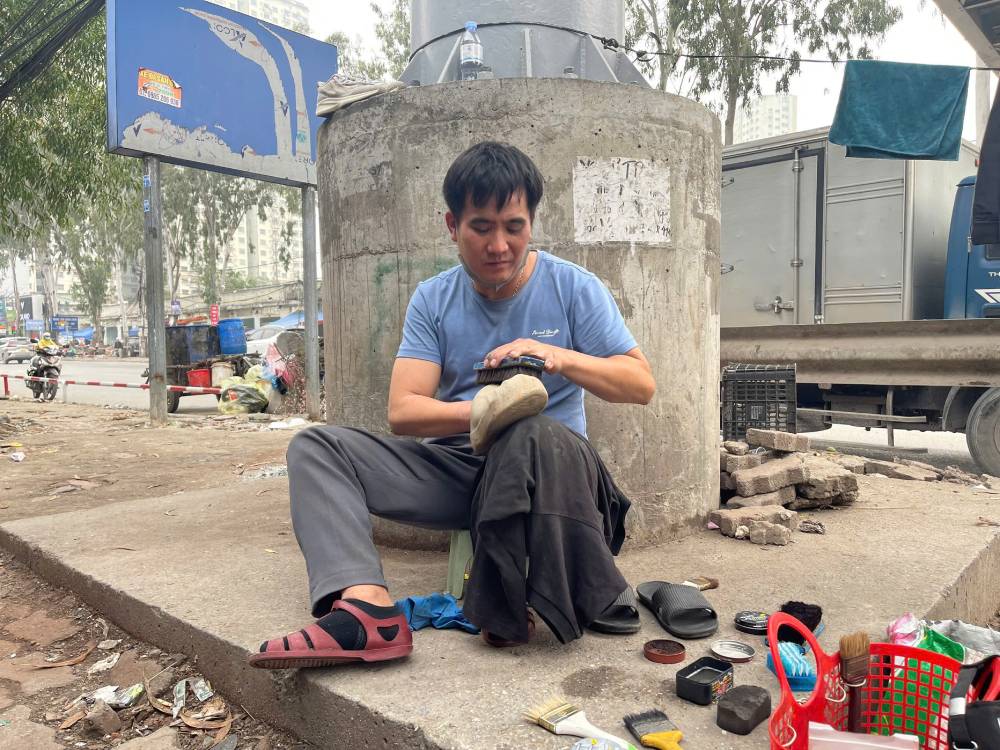 Half-paralyzed due to sequelae of illness, Mr. Hung still tries to shine shoes every day to have money to take care of his wife and children. Photo: Quynh Chi