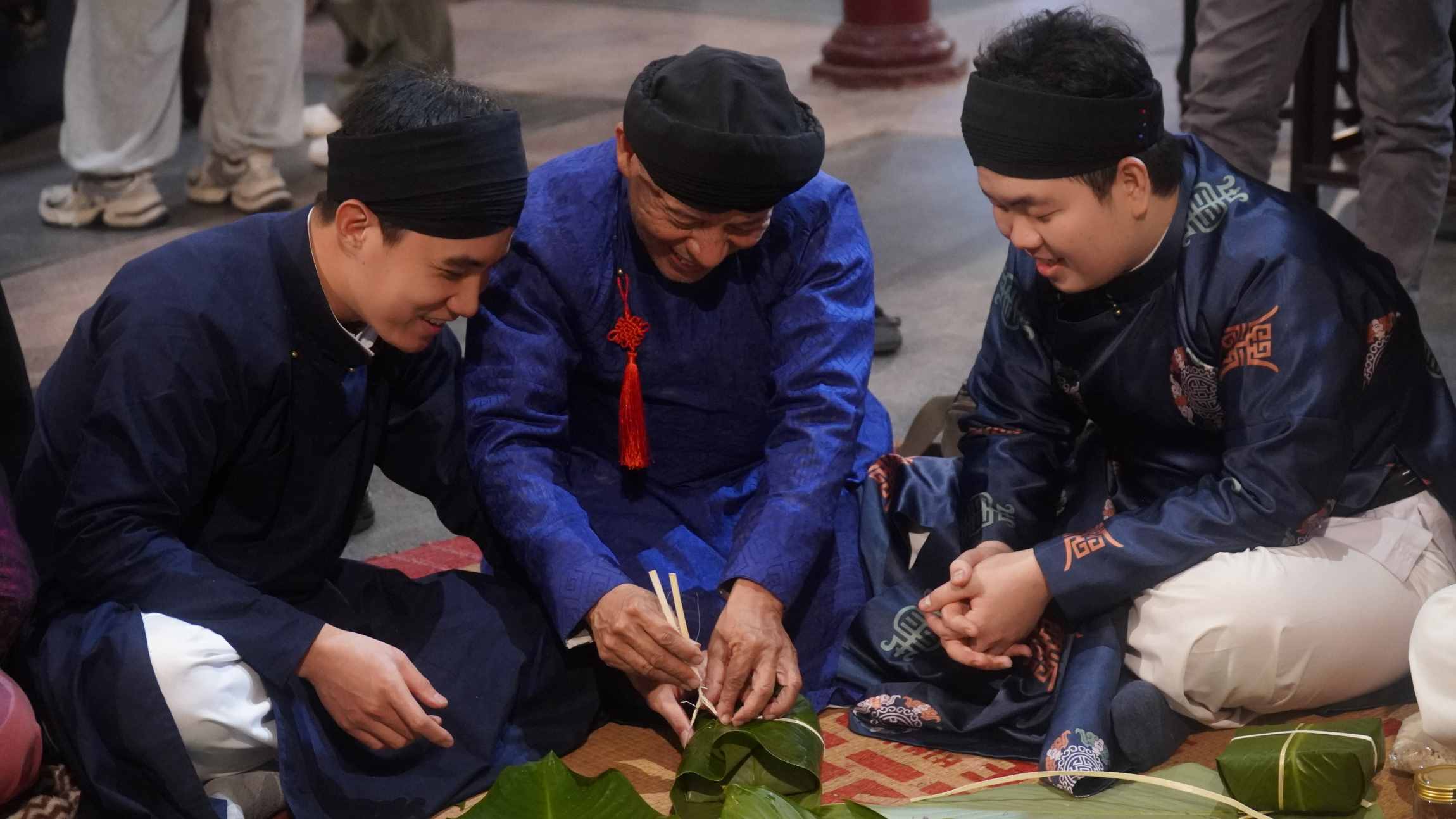 Bạn Dương Văn Phúc (bên phải) chia sẻ rất hào hứng khi được cùng các bác và anh chị làm bánh chưng ngày Tết. Ảnh: Minh Vũ