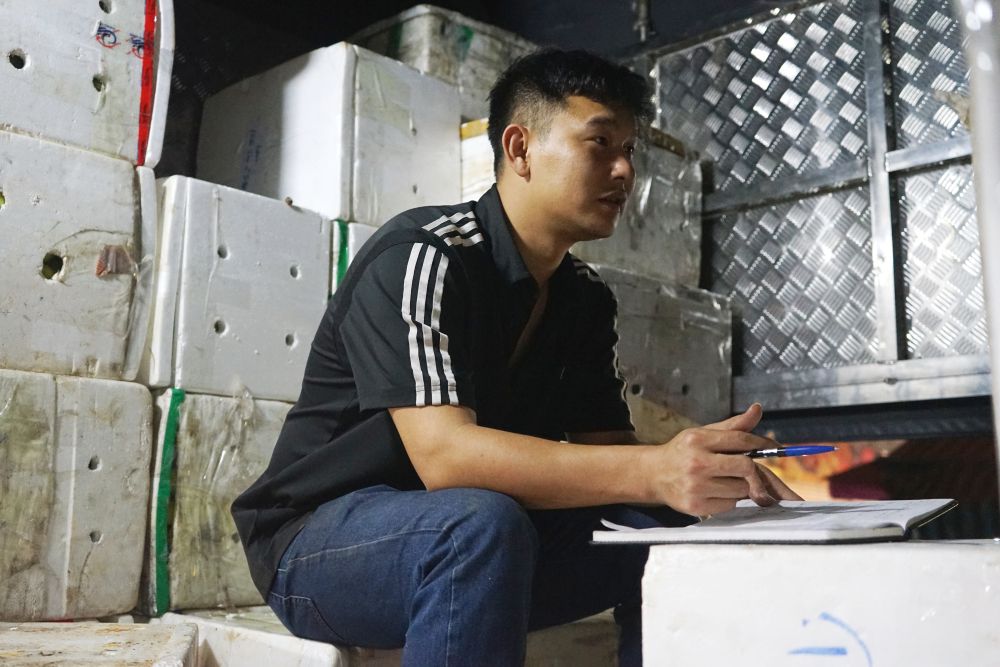 Anh Hoàng Đức Cảnh (trú tại tỉnh Hưng Yên) ngồi chờ bán hàng cho các tiểu thương tại chợ đầu mối. Ảnh: Quách Du