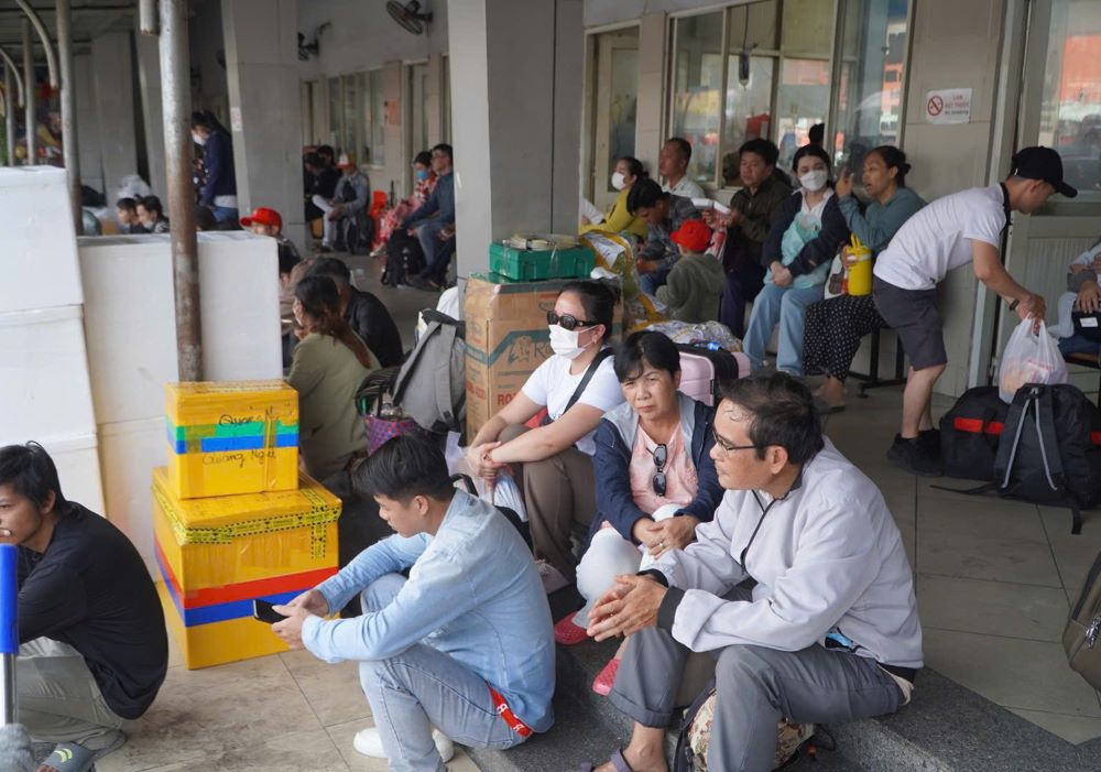 Bên trong nhà chờ, nhiều hành khách phải ngồi tạm trên hành lý do hết ghế.