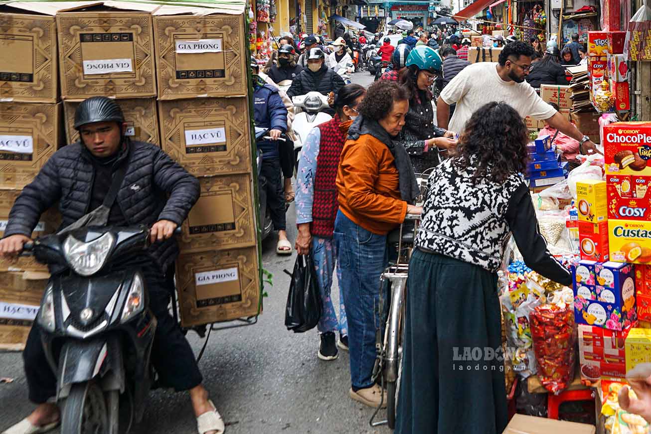 Hơn một tuần trước Tết Bính Ngọ, phố Hàng Giày, Hàng Buồm (Hà Nội) tấp nập người mua, kẻ bán bánh kẹo, mứt Tết. Ảnh: Hữu Vũ 