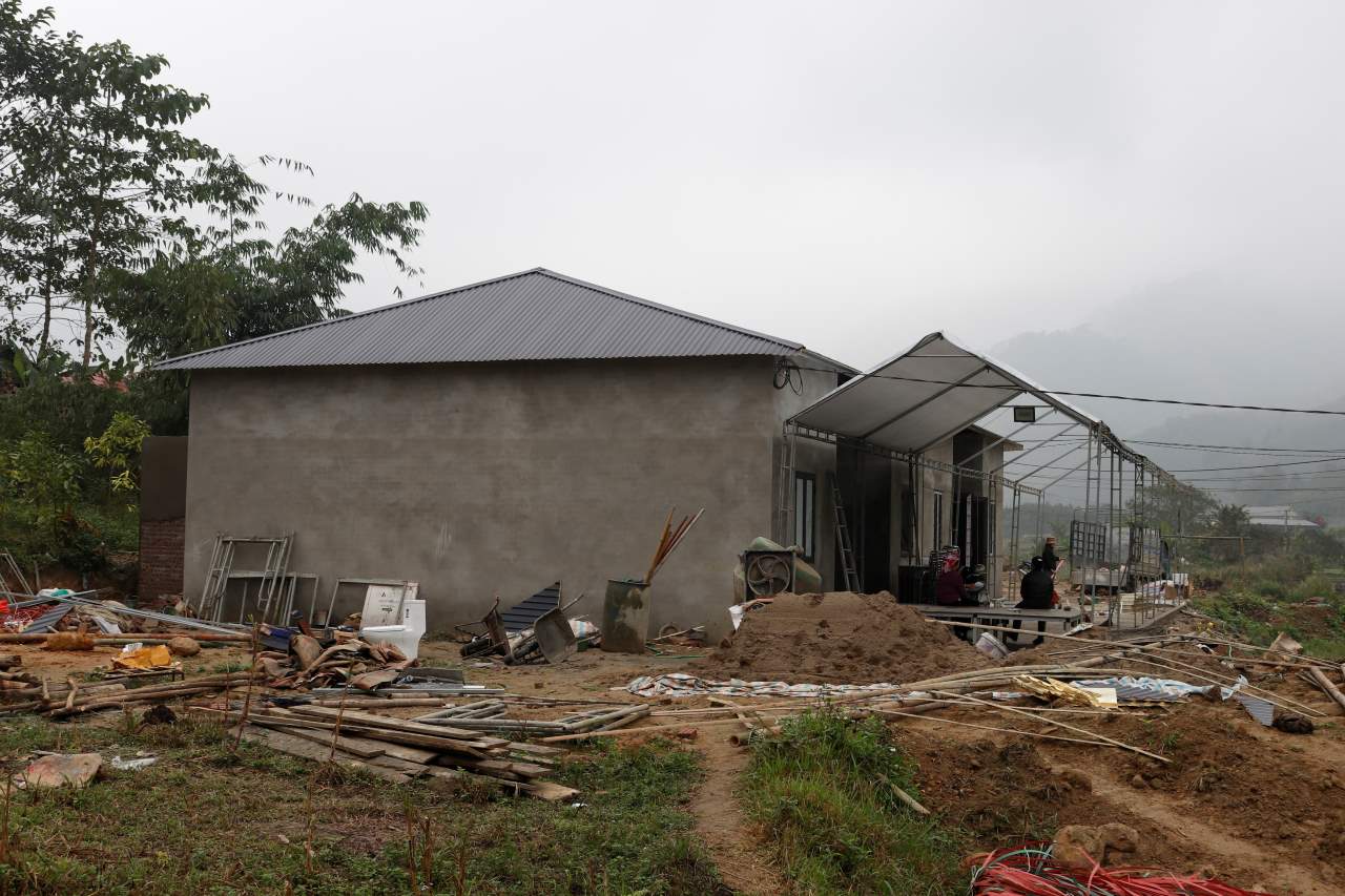 Bà Nhuận tất bật dọn dẹp nhà cửa để mời bà con lối xóm đến ăn nhà mới. Ảnh: Văn Đức