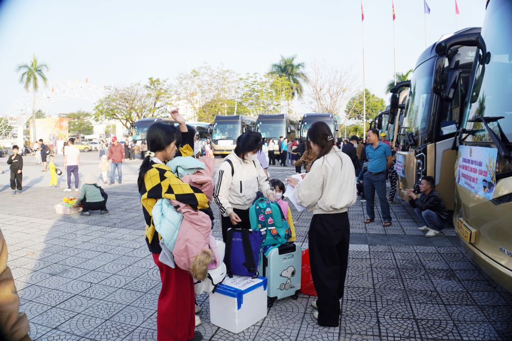 Nhiều gia đình có mặt tại điểm xuất phát từ sớm để kịp giờ lên “Chuyến xe Công đoàn” về quê đón Tết. Ảnh: Trần Thi