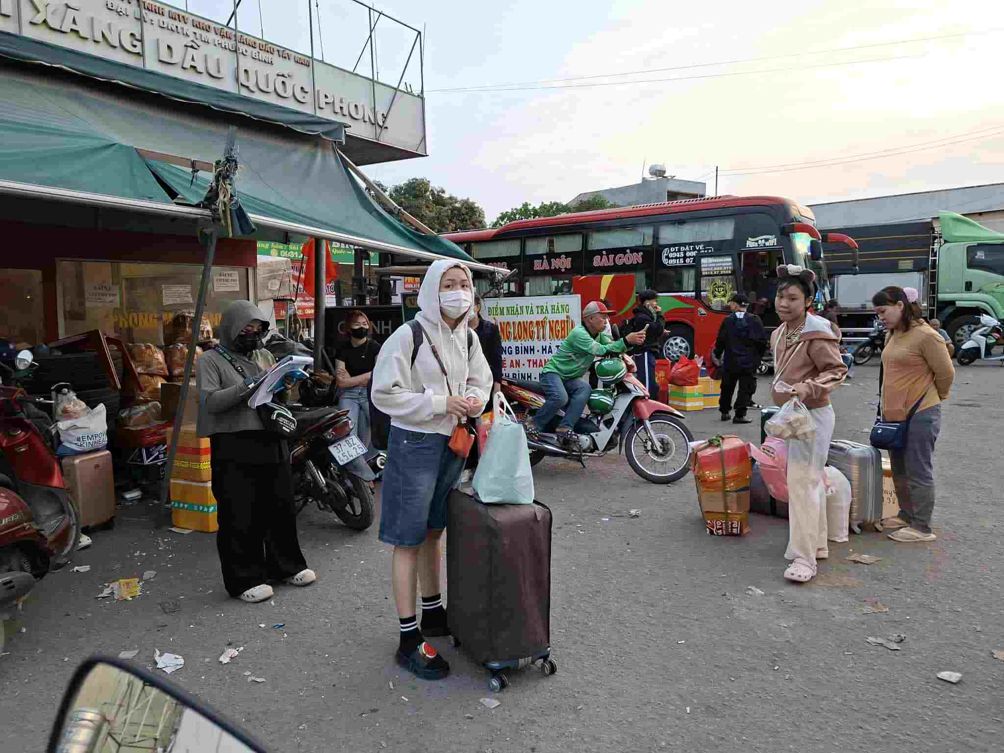 Hành khách chờ xe tại một bãi giữ xe trên Quốc lộ 1, gần cầu vượt Gò Dưa.  Ảnh: Minh Quân
