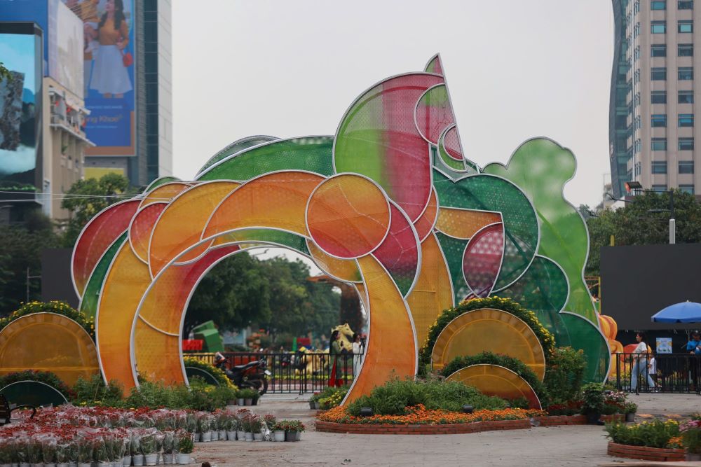 Đại cảnh “Lý ngựa ô” với tạo hình vui nhộn đã hoàn tất phần khung chính. Bề mặt linh vật phủ hiệu ứng sơn mài kết hợp hoa văn mây sóng 3D hologram bắt đầu bắt sáng dưới nắng chiều, tạo hiệu ứng óng ánh nổi bật. Trong khi đó, “Ngựa chín hồng mao” cao 6,4 m lấy cảm hứng từ truyền thuyết Sơn Tinh – Thủy Tinh cũng đã được hoàn thiện lớp màu chuyển sắc. Các gam nóng – lạnh đan xen giúp mô hình thay đổi sắc thái theo từng góc nhìn. Ảnh: Anh Tú.