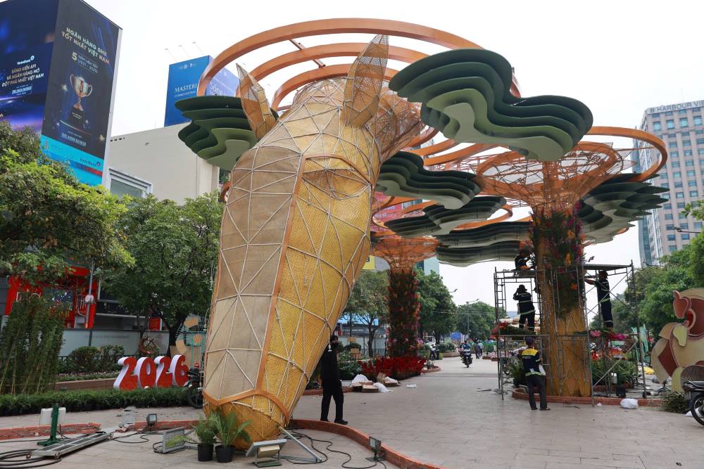 Ở trung tâm đường hoa, đại cảnh “Nhất mã thong dong” cũng đã lộ rõ hình hài. Mô hình ngựa cao gần 7 m, làm từ tre đan thân thiện môi trường, đang trong những bước hoàn thiện cuối cùng. Không gian sinh thái đa tầng xung quanh dần phủ kín hoa lá, hứa hẹn mang lại cảm giác thư thái cho người dạo bước. Ảnh: Anh Tú.