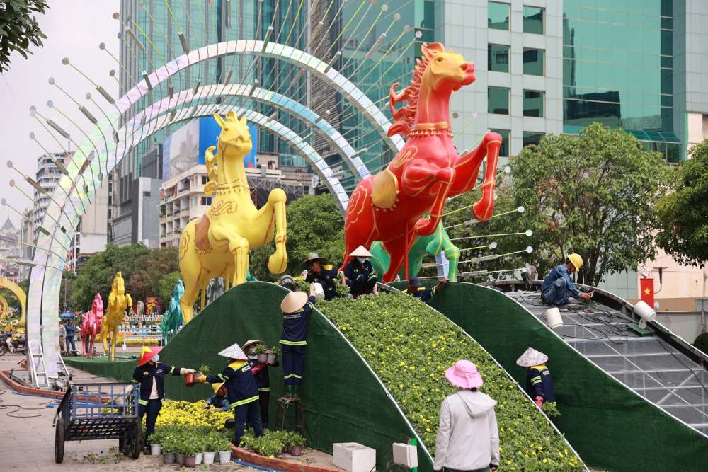 Hôm nay, 27 Tết, không khí thi công tại khu trung tâm trở nên khẩn trương hơn bao giờ hết. Sau gần một tháng lắp dựng, các đại cảnh lớn đã cơ bản thành hình, chỉ còn những công đoạn trang trí hoa, chỉnh sửa kỹ thuật và vệ sinh tổng thể trước giờ đón khách vào tối 28 tháng Chạp. Ảnh: Thái Bảo.