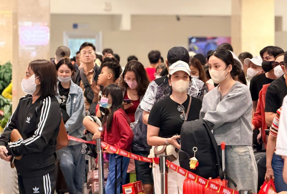 Đông đúc người dân xếp hàng chờ làm thủ tục và gửi hành lí tại sảnh đi ga  T1 quốc nội sáng 27 Tết. Ảnh: Anh Tú