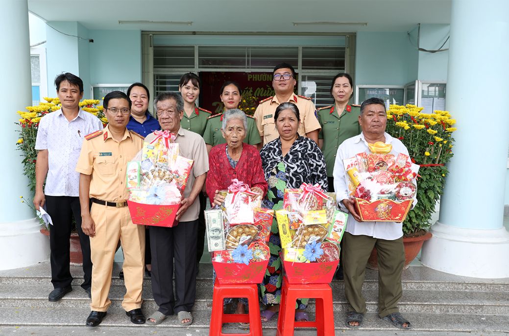 Các lực lượng phố hợp tặng quà tết cho người dân có hoàn cảnh khó khăn trên địa bàn phường Mỹ Thới. Ảnh: Vũ Tiến