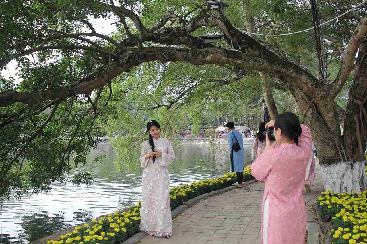 Giới trẻ mặc áo dài check-in tại hồ Bán Nguyệt. 