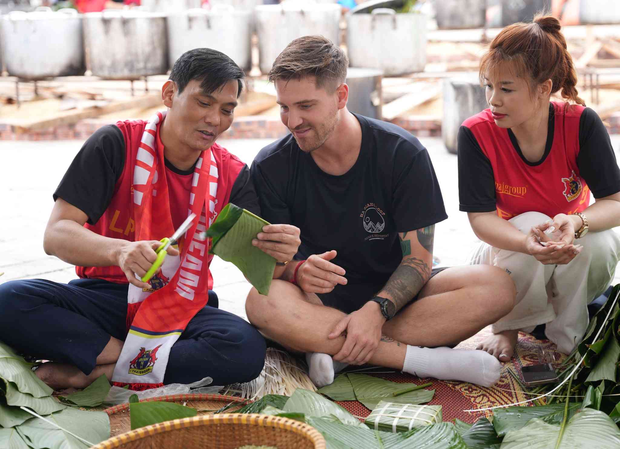 Du khách nước ngoài thích thú trải nghiệm gói bánh chưng tại khu du lịch Tam Cốc - Bích Động. Ảnh: Diệu Anh