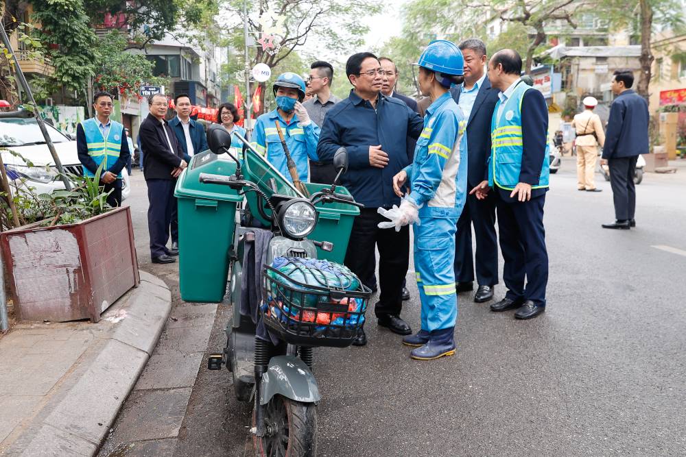 Thủ tướng Chính phủ thăm và động viên công nhân môi trường đô thị đang thực hiện nhiệm vụ tại Phố Nguyễn Thái Học. Ảnh: VGP/Nhật Bắc  
