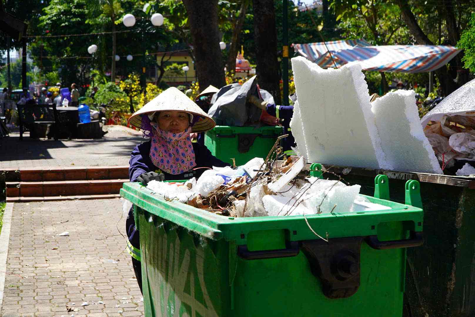 Các công nhân vệ sinh môi trường tất bật dọn dẹp tại chợ hoa Công viên 23.9. Ảnh: Chân Phúc