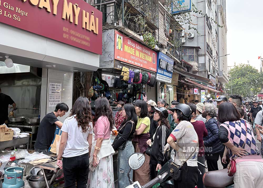 Khách xếp hàng dài chờ mua chim quay, gà quay ở chợ Hàng Bè. Ảnh: Ý Yên