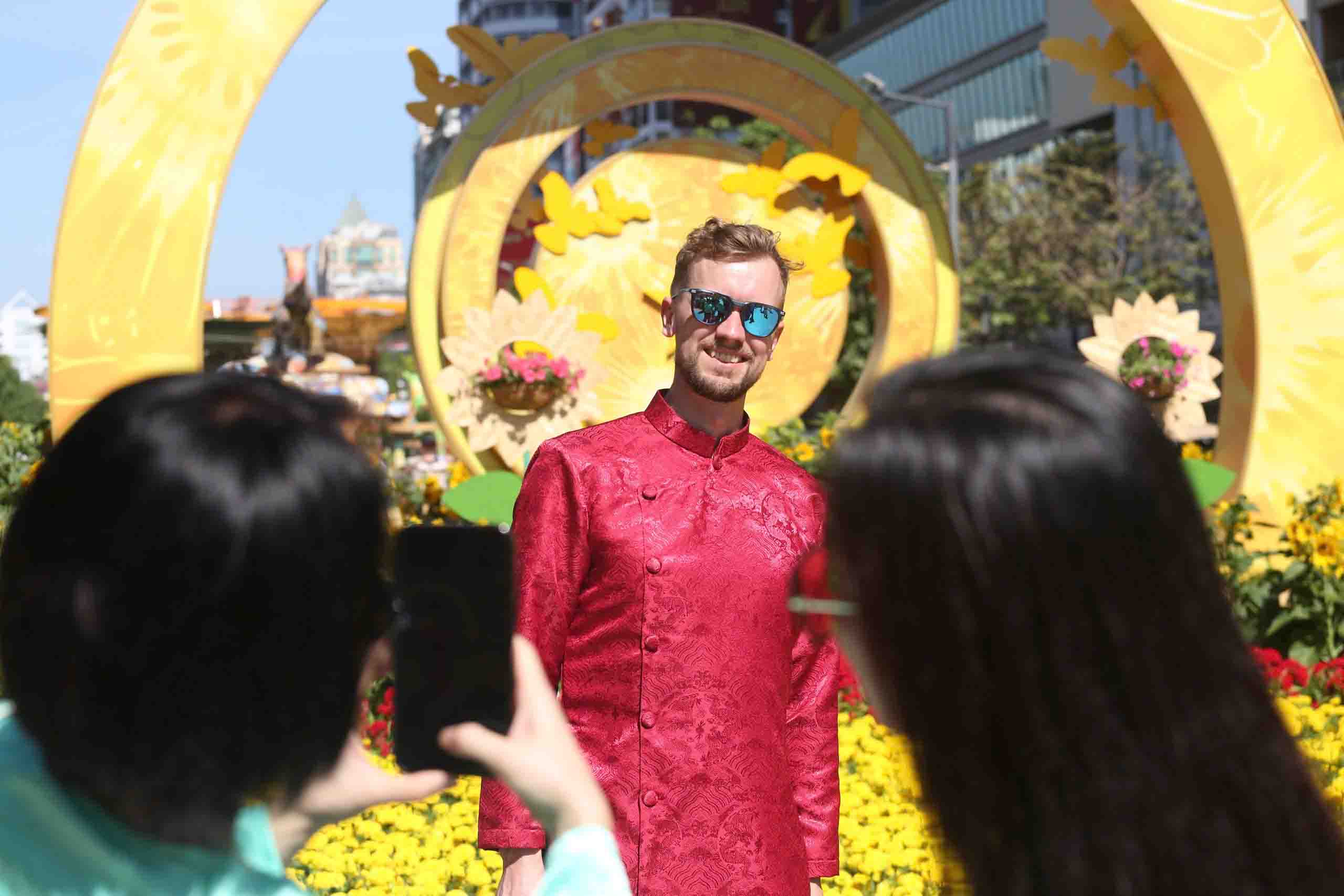 Nhiều du khách nước ngoài vừa tham quan vừa ghi lại khoảnh khắc đáng nhớ. Một số du khách nước ngoài tỏ ra thích thú trước không gian ngập tràn hoa và sắc màu truyền thống Việt Nam.