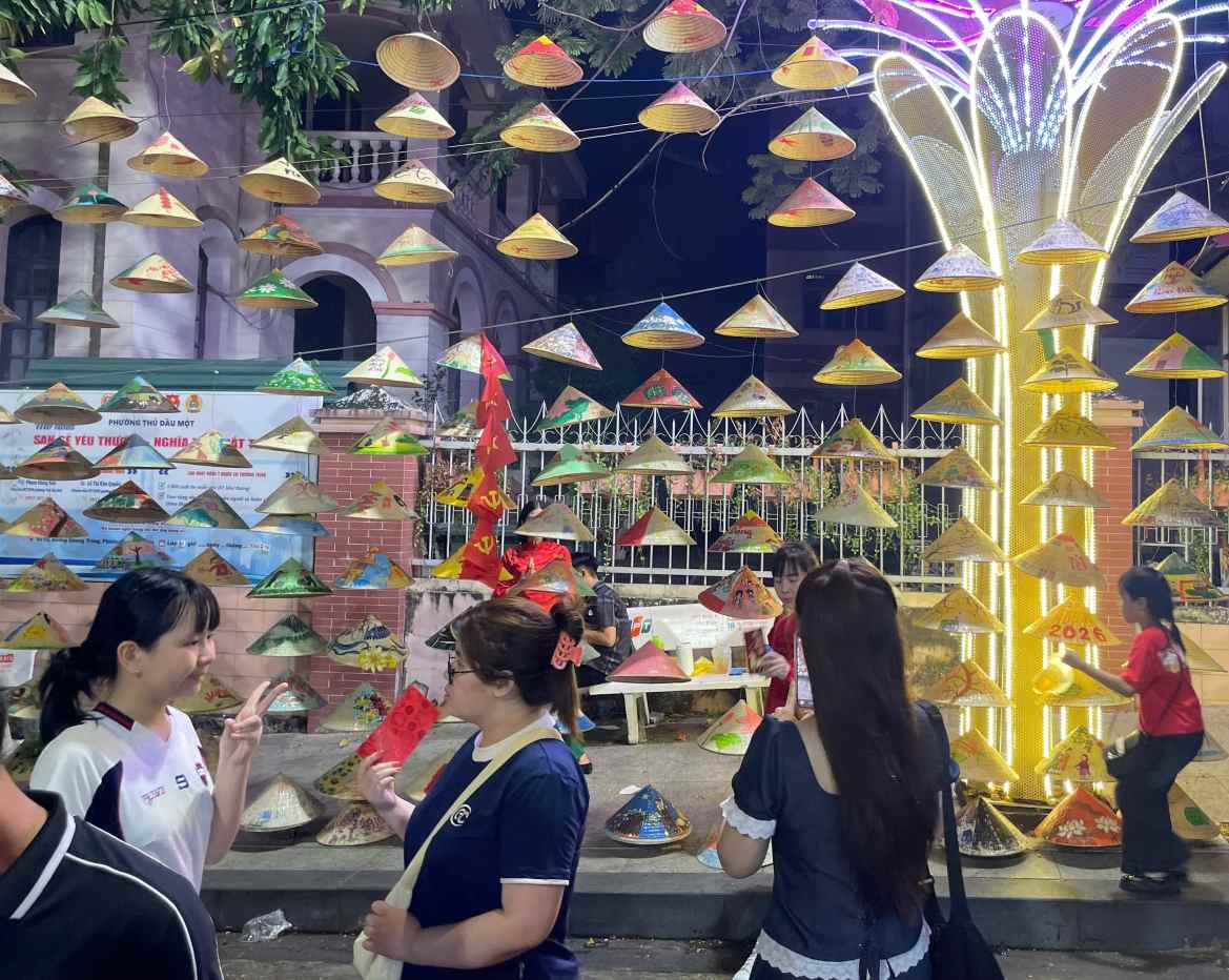 Không gian trưng bày heo đất và tranh trên nón lá thu hút người dân tham quan, chụp hình lưu niệm. Ảnh: Đình Trọng