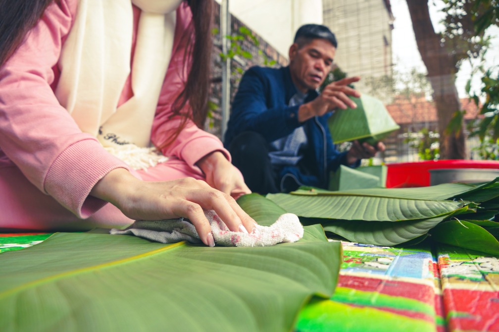 Chị Yến Phương chuẩn bị nguyên liệu và lau lá bánh. Ảnh: Tạ Quang