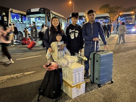 Ms. Tran Thi Minh Nguyet's family as well as many other workers bring bouquets of flowers and luggage back to their hometown for Tet. Photo: Kieu Vu