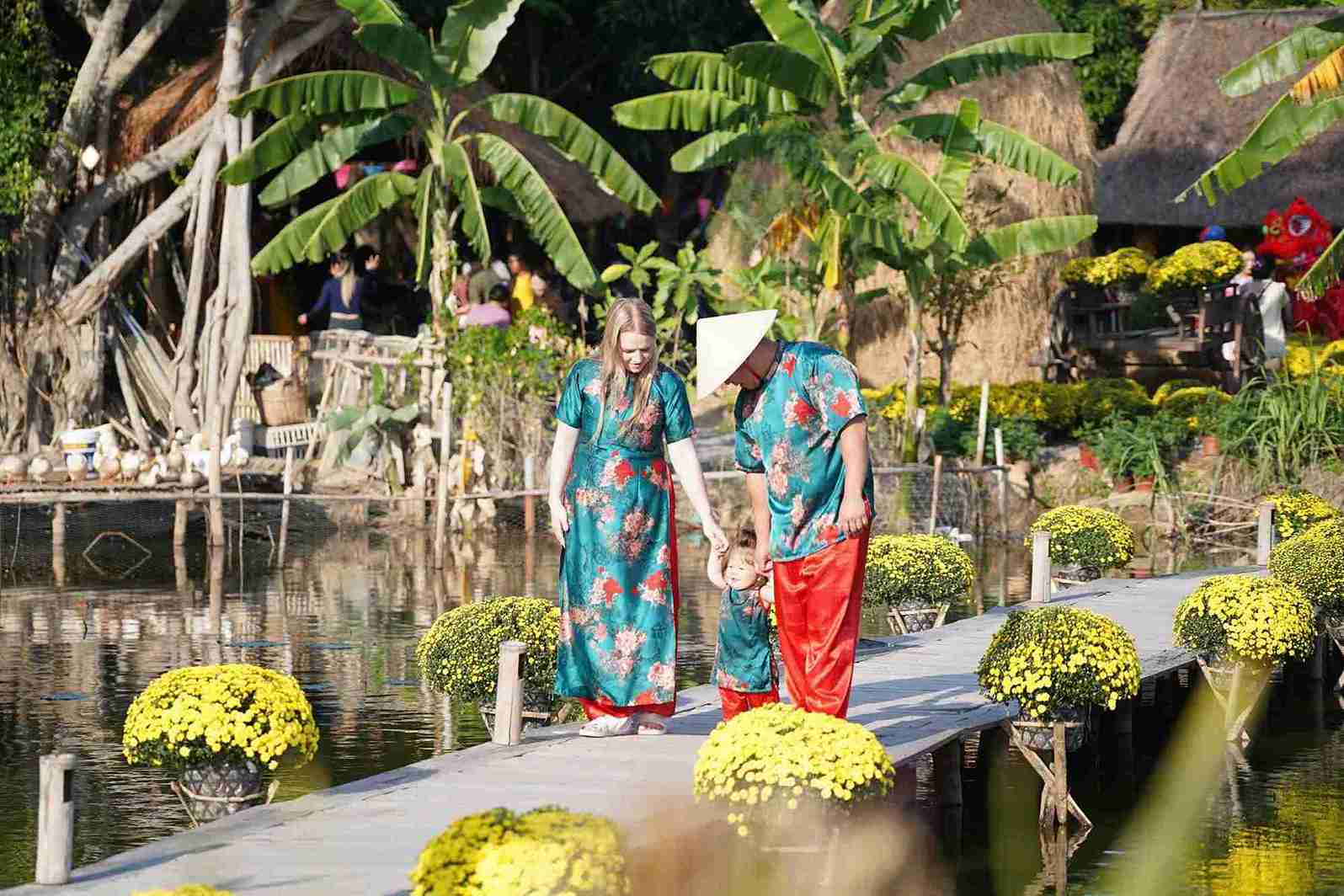 Khách nước ngoài hạnh phúc bên trang phục áo dài truyền thông của Việt Nam. Ảnh: Hữu Long