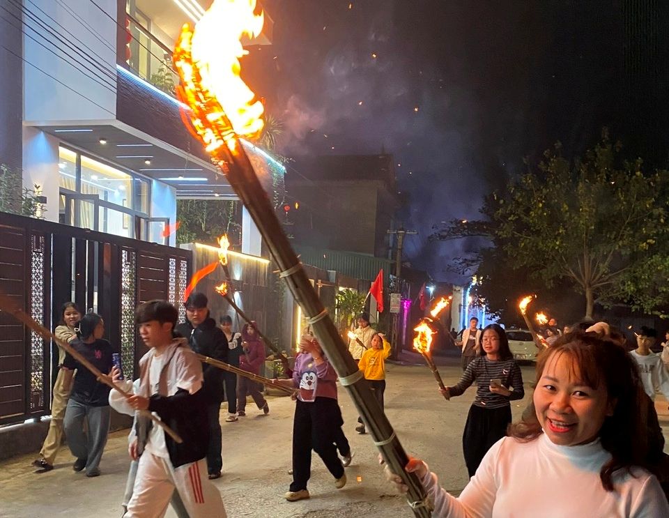 Người dân mỗi người một bó đuốc trên tay, để xin lửa từ đình làng mang về nhà để cầu may đầu năm mới. Ảnh: Quách Du