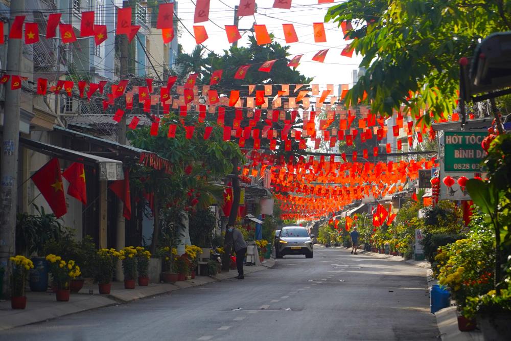 Những con hẻm nhỏ, khu phố ngày thường náo nhiệt tiếng còi xe, tiếng rao hàng, sáng nay bỗng “ngủ yên” trong sự tĩnh mịch. Cờ đỏ sao vàng rực rỡ trước hiên nhà hòa cùng tiết trời dịu mát tạo nên khung cảnh thanh bình, ấm cúng. Ảnh: Anh Tú