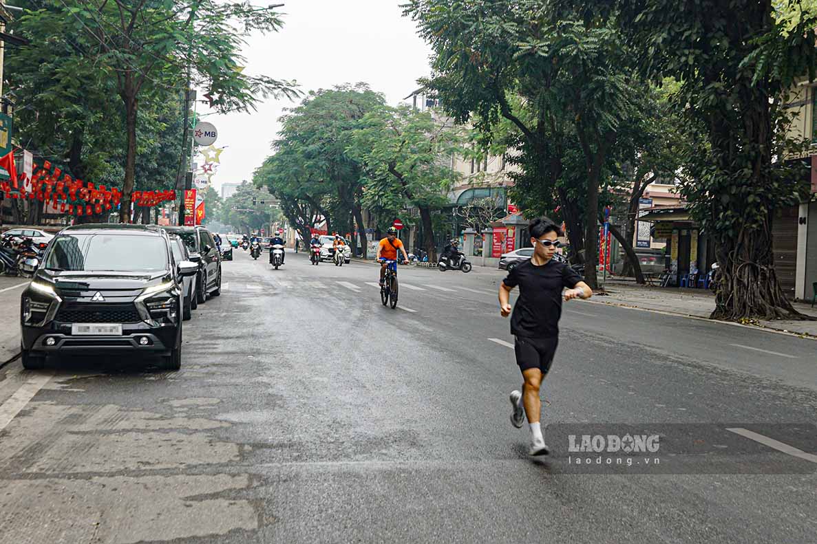 Người dân chạy bộ, tập thể dục trên phố Nguyễn Thái Học khi dòng phương tiện thưa thớt.