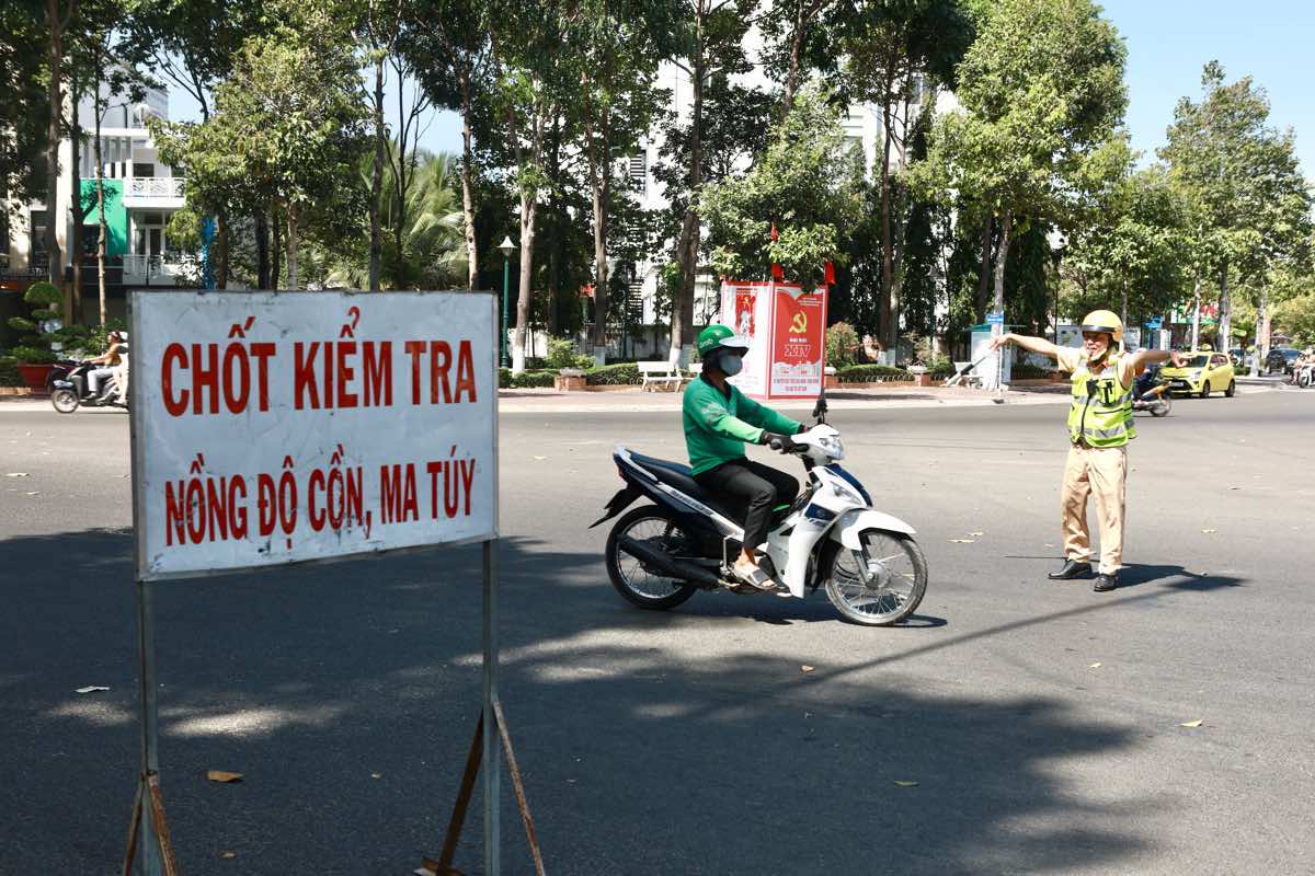 Một tài xế xe ôm công nghệ bị dừng xe kiểm tra nồng độ cồn. Ảnh: Duy Tuấn 