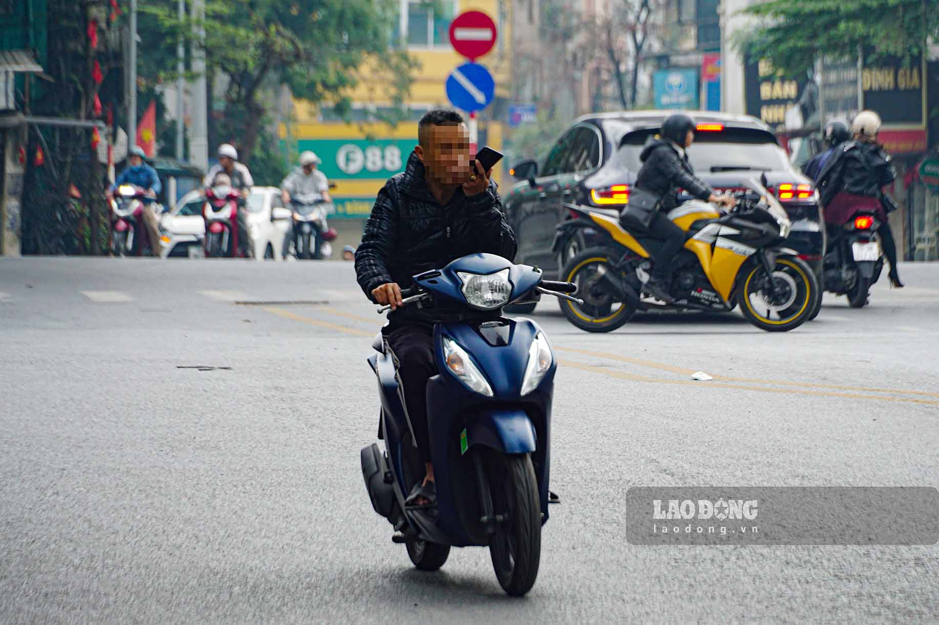 Người đi đường ngang nhiên sử dụng điện thoại và không đội mũ bảo hiểm trên đường Thanh Niên.