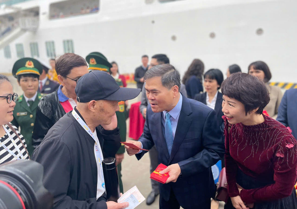 Mr. Bui Van Khang, Chairman of Quang Ninh Provincial People's Committee, congratulates the new year and gives lucky money to international tourists. Photo: Doan Hung