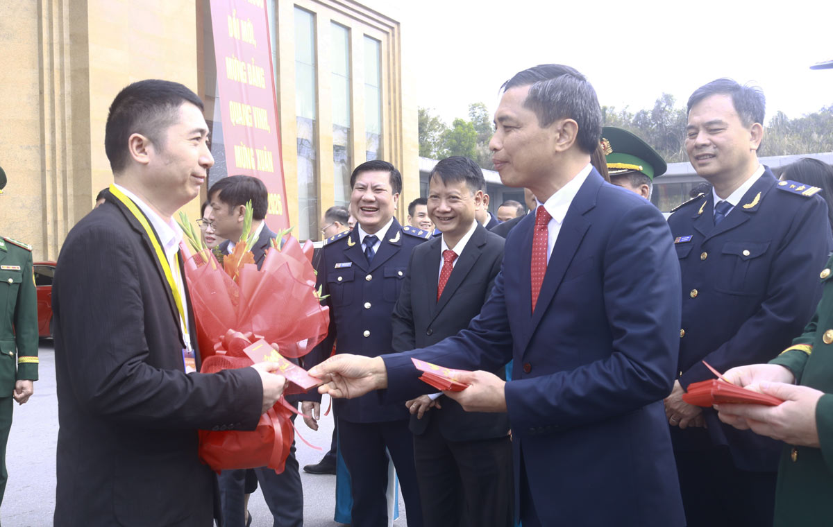 부반디엔 꽝닌성 인민위원회 상임 부위원장이 새해를 축하하고 관광객들에게 세뱃돈을 주고 있습니다. 사진: 몽까이 1동 전자 정보 포털