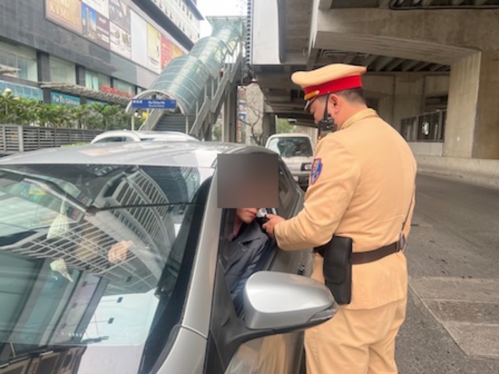 Cán bộ, chiến sĩ Đội Cảnh sát Giao thông đường bộ số 6 thực hiện dừng xe ô tô, kiểm tra nồng độ cồn của người điểu khiển phương tiện tại ngã 3 Trần Đăng Ninh – Cầu Giấy sáng Mùng Hai Tết. Ảnh: Kiều Vũ